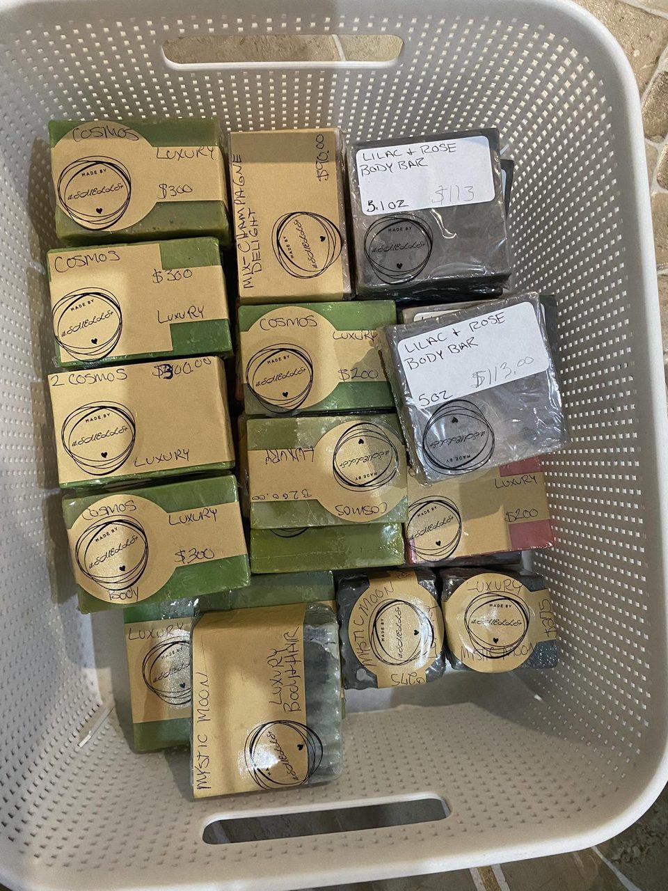 A basket of itSMELLS+ soaps individually wrapped in kraft paper with hand-stamped seals